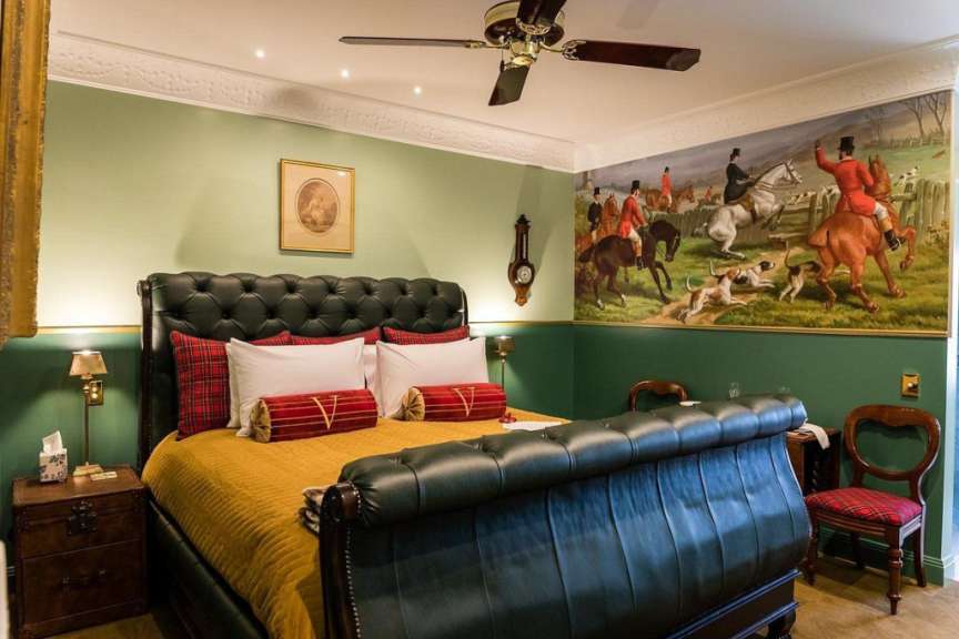 Ein Schlafzimmer mit einem Bett und einem Gemälde an der Wand