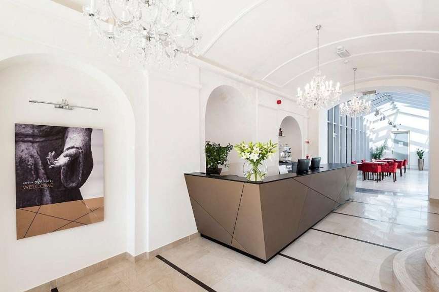 Ein schwarz-weißes Gemälde hängt an einer weißen Wand neben einem Hotelrezeptionstisch
