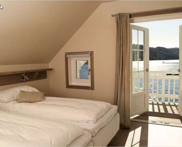 Ein Schlafzimmer mit zwei Betten und einem Fenster mit Blick auf einen See