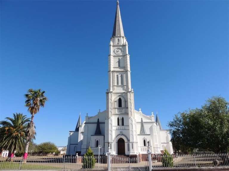Eine sehr alte weiße Kirche mit einem Uhrturm