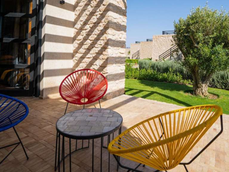 Eine Terrasse mit bunten Stühlen und einem Tisch