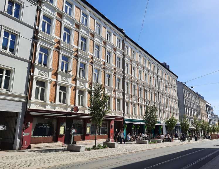 Eine Gruppe von Menschen sitzt vor einem Gebäude mit einem Schild, das sagt „ new amsterdam “