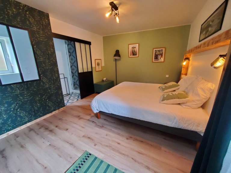 Ein Schlafzimmer mit einem Bett und einer grünen Wand