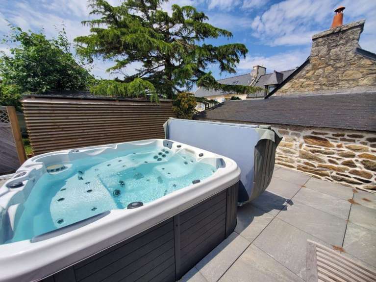 Ein Whirlpool auf einer Terrasse mit einem Baum im Hintergrund