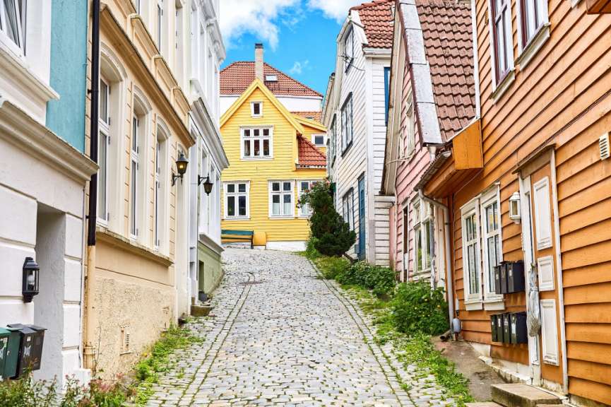 Eine schmale Straße mit einem gelben Haus in der Mitte