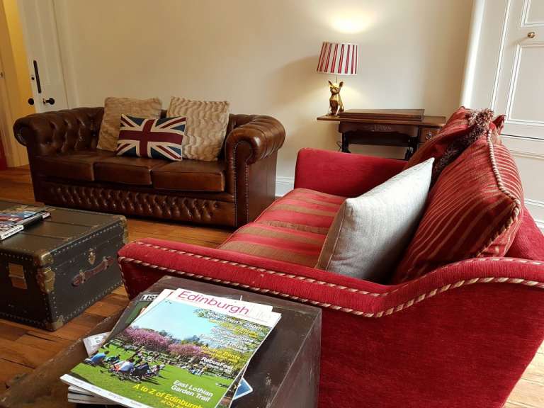 Ein Wohnzimmer mit einem roten Couch und einem braunen Couchtisch