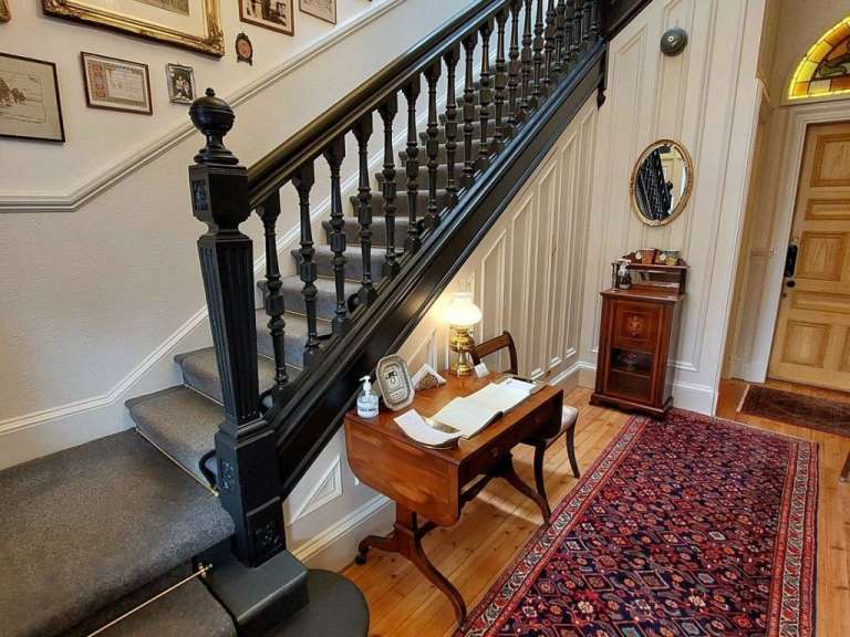 Eine Treppe mit einem Tisch und einem Spiegel darunter