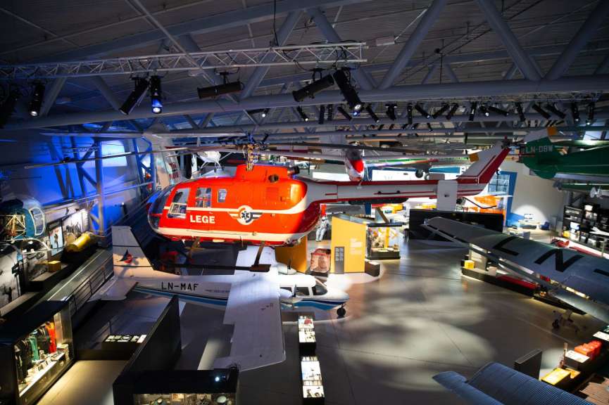 Ein rot-weißer Hubschrauber mit der Aufschrift lege hängt in einem Museum