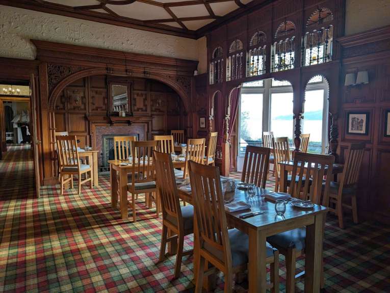 Ein Esszimmer mit Tischen und Stühlen und einem karierten Teppich