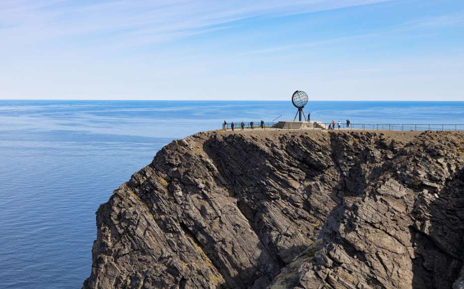 Eine Gruppe von Menschen steht auf einer Klippe über dem Ozean