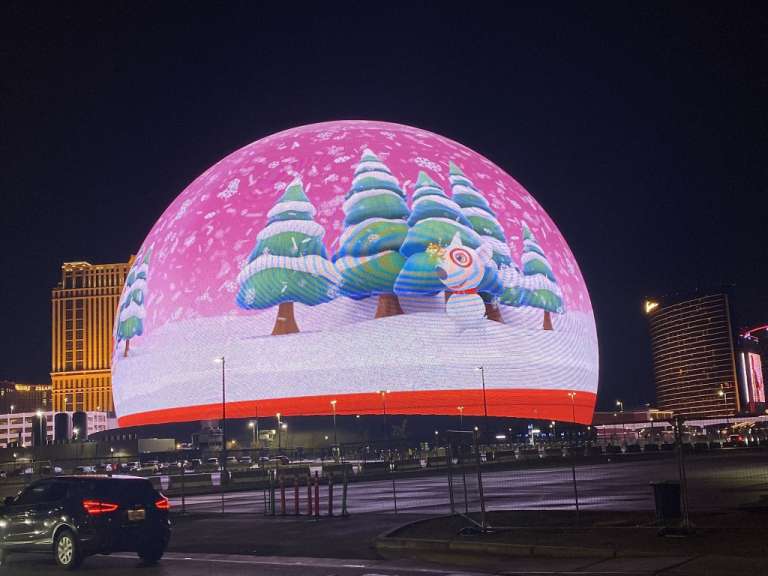 Eine große Schneekugel mit Bäumen und einem Weihnachtsmann darauf