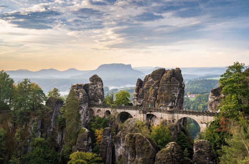 Eine Brücke über einen Fluss mit einem Berg im Hintergrund