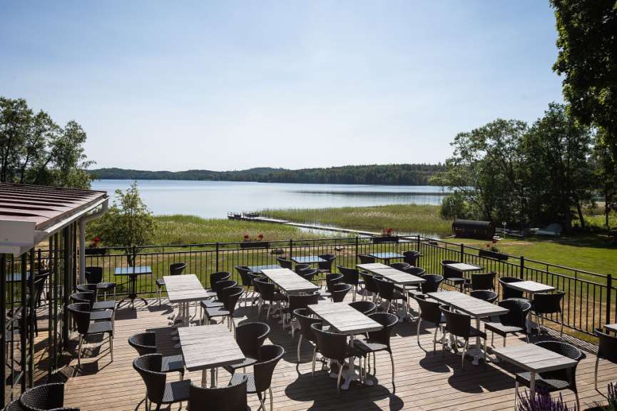 Tische und Stühle auf einem Deck mit Blick auf einen See