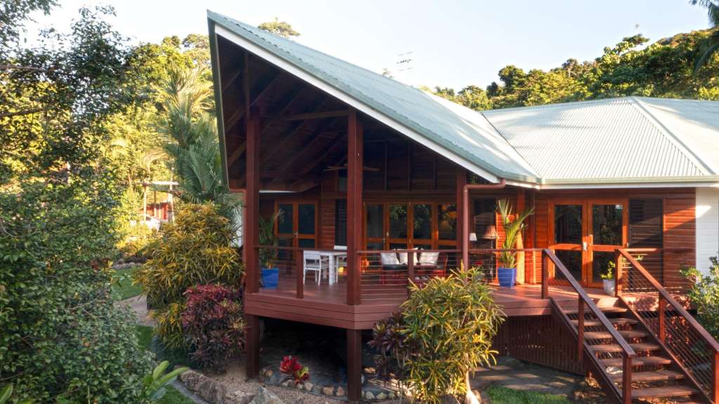 Ein kleines Haus mit einem roten Deck und einer Treppe