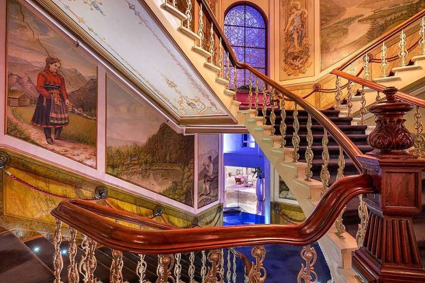 Eine Treppe in einem Gebäude mit Gemälden an den Wänden