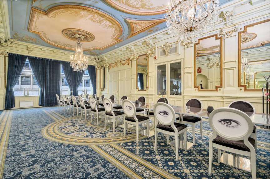 Ein Esszimmer mit vielen Stühlen und Tischen