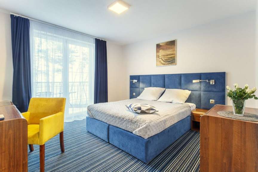 Ein Hotelzimmer mit einem großen Bett und einem gelben Stuhl
