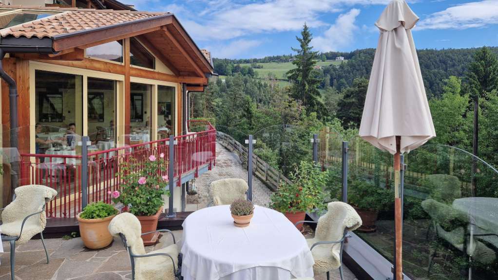 Ein Tisch und Stühle auf einem Balkon mit Blick auf die Berge