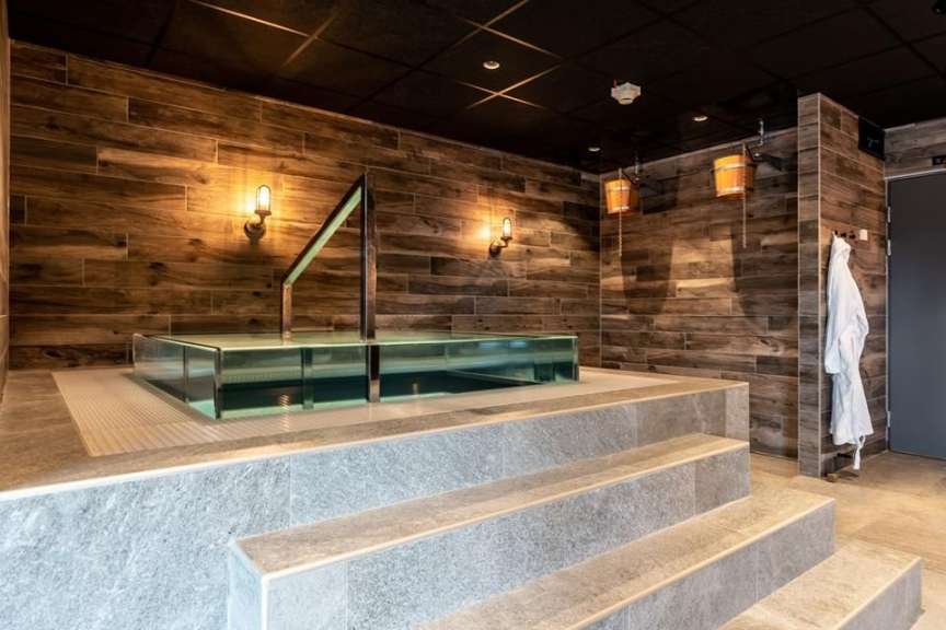 Eine Badewanne in einem Badezimmer mit Holzwänden