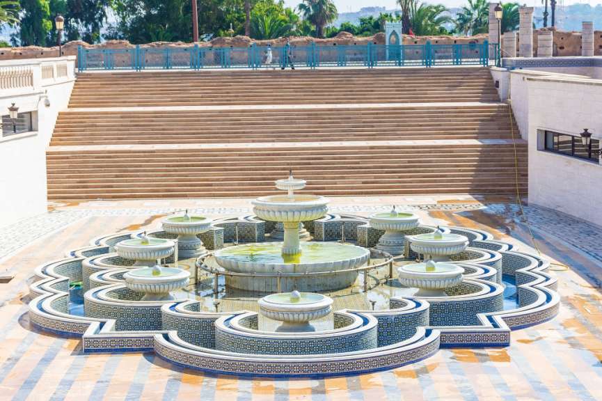 Ein Brunnen in einem Park mit Treppen im Hintergrund