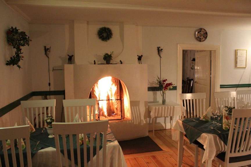 Ein Wohnzimmer mit einem Kamin und Tischen und Stühlen