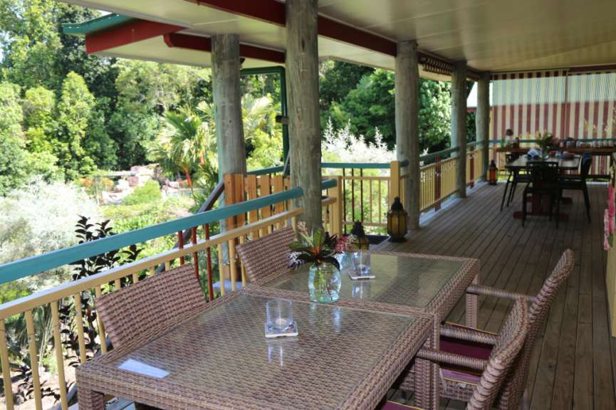 Ein Tisch und Stühle auf einem Deck mit Blick auf einen Garten