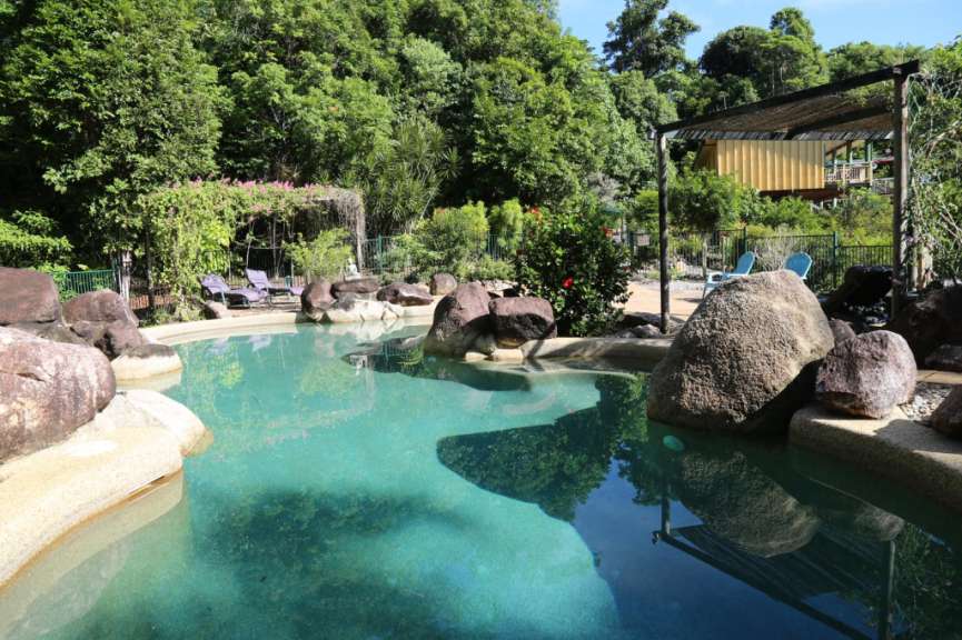 Ein großer Swimmingpool umgeben von Felsen und Bäumen