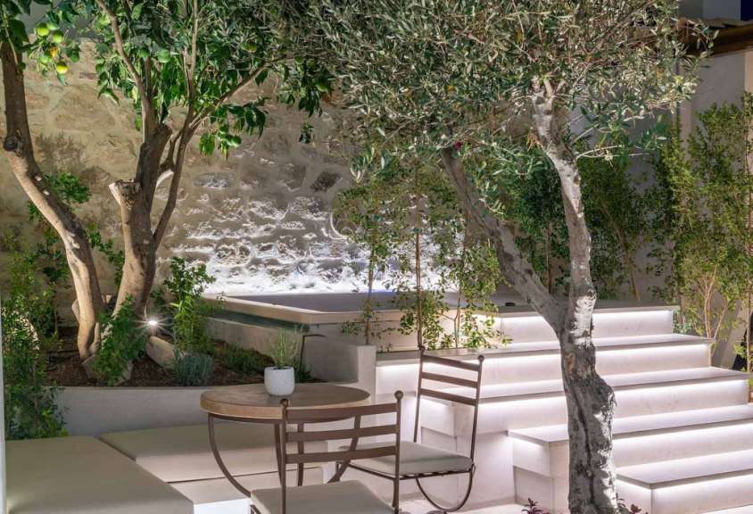 Ein Tisch und ein Stuhl in einem Garten neben einer Treppe