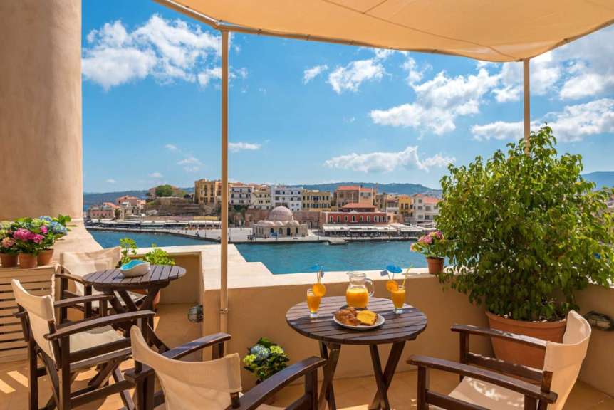 Ein Balkon mit einem Tisch und Stühlen mit Blick auf den Hafen