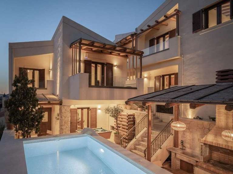 Ein großes weißes Haus mit einem Pool im Vordergrund