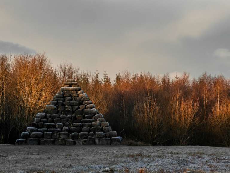Ein Pyramide aus Steinen inmitten eines Waldes