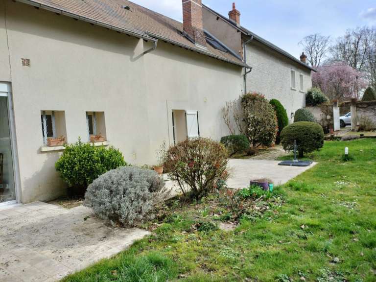 Ein Haus mit einer Terrasse und einem Garten davor