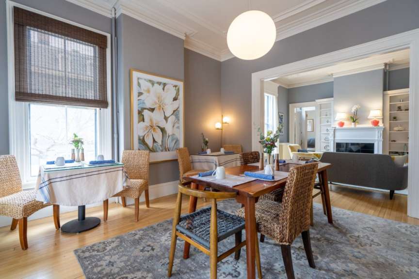 Ein Esszimmer mit einem Tisch und Stühlen und einem Gemälde an der Wand