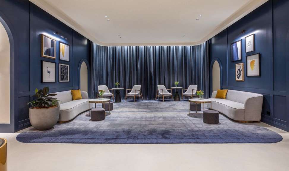 Ein Wohnzimmer mit blauen Wänden und weißen Möbeln