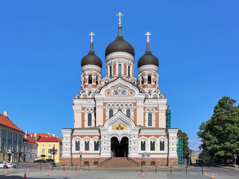 Eine große rote und weiße orthodoxe Kirche mit drei kuppelförmigen Türmen