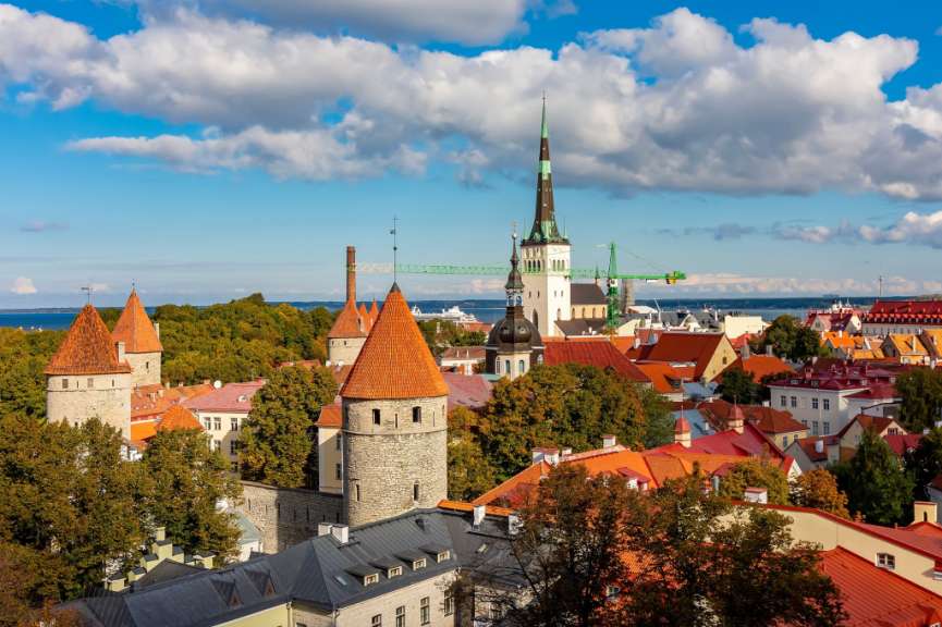 Eine Stadtlandschaft mit roten Dächern und einem Turm