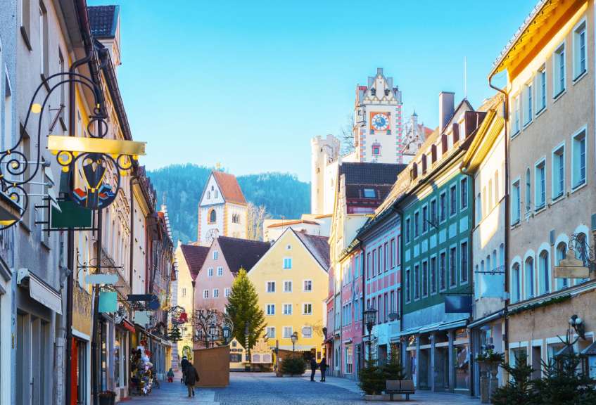 Eine Stadtstraße mit vielen Gebäuden und einem Schild, das sagt ' apotheke '