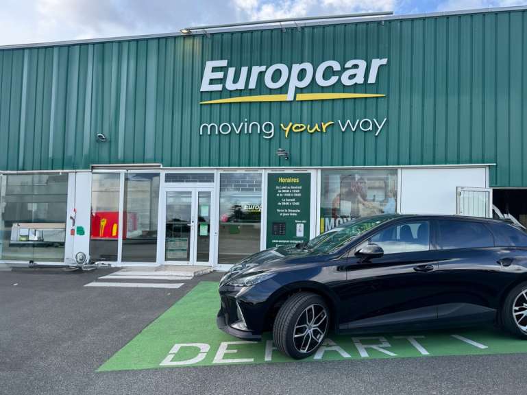 Ein schwarzes Auto steht vor einem europacar-Geschäft