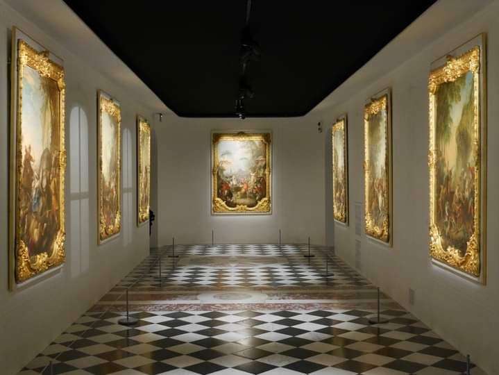 Ein Museum mit vielen Gemälden und einem karierten Boden