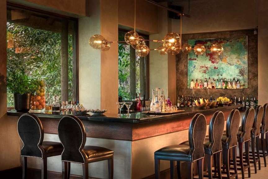 Eine Bar mit Stühlen und Flaschen an der Wand