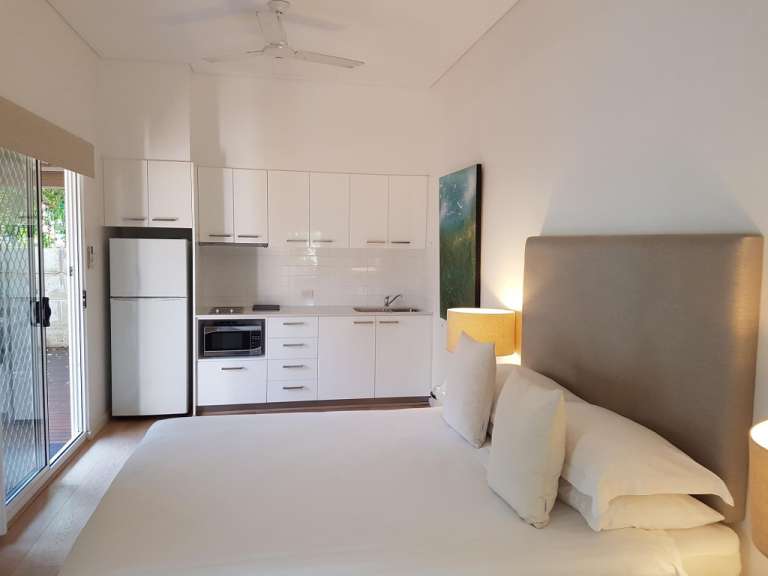 Ein Schlafzimmer mit einem Bett und einer kleinen Küche