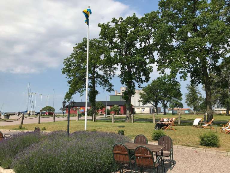 Ein Tisch und Stühle in einem Park mit einer Flagge im Hintergrund