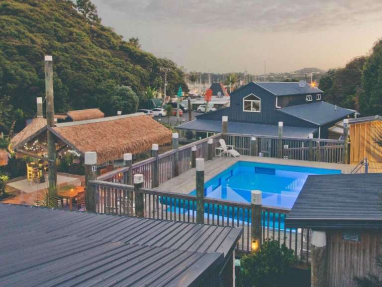 Ein großer blauer Pool auf einem Deck neben einem Haus