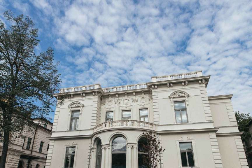 Ein großes weißes Gebäude mit einem Balkon und vielen Fenstern
