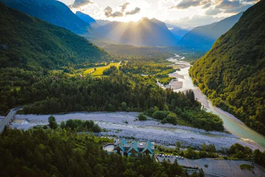 Die Sonne scheint durch die Wolken über einen Fluss