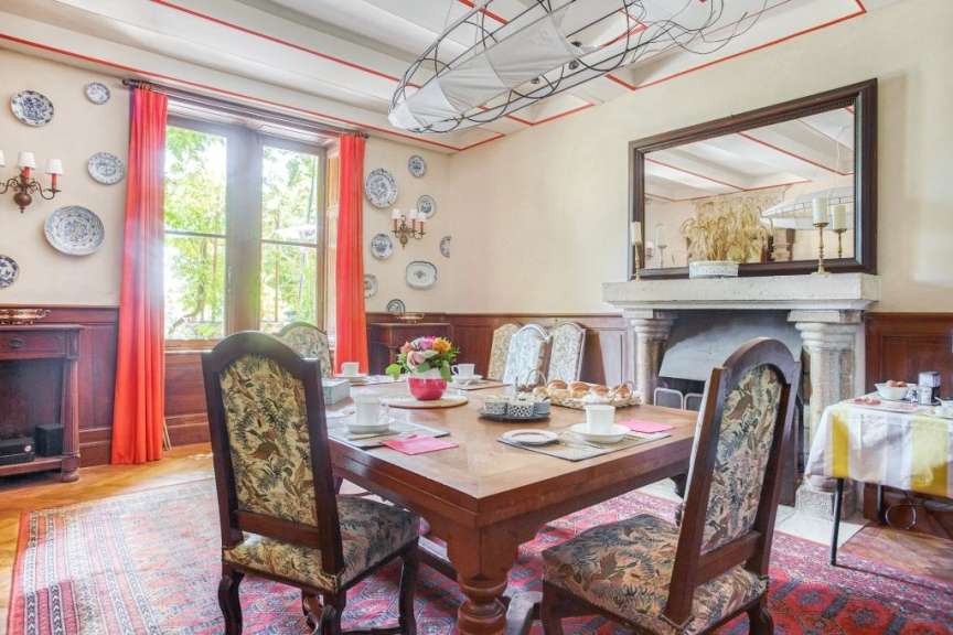 Ein Esszimmer mit einem Tisch und Stühlen und einem Kamin