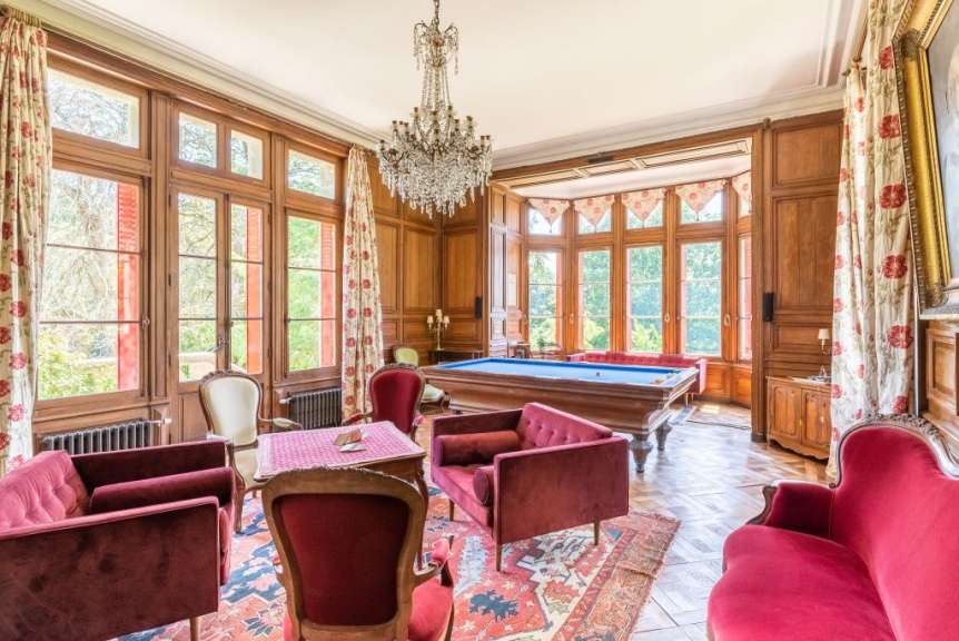 Ein Wohnzimmer mit Pooltisch und roten Möbeln