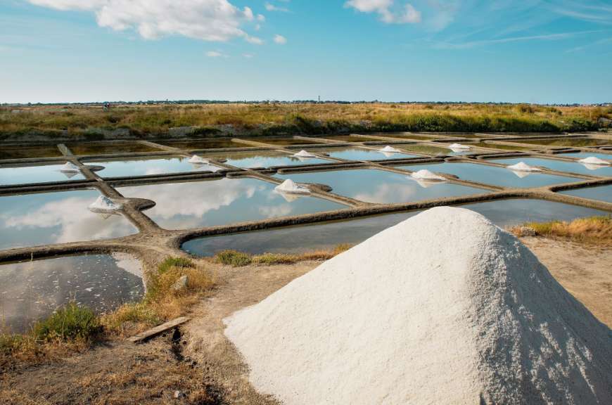 Ein großer Haufen Salz steht in der Nähe von Wasserbecken