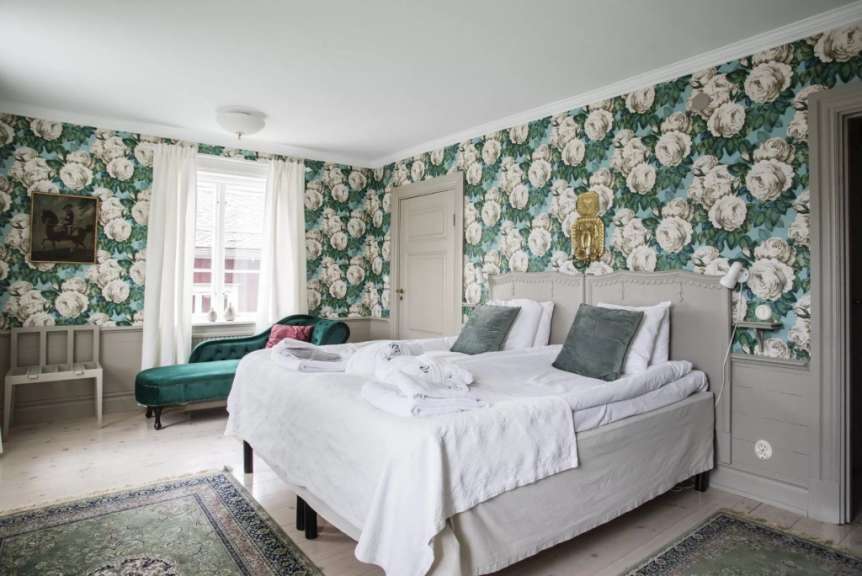 Ein Schlafzimmer mit Blumentapeten und einem Bett