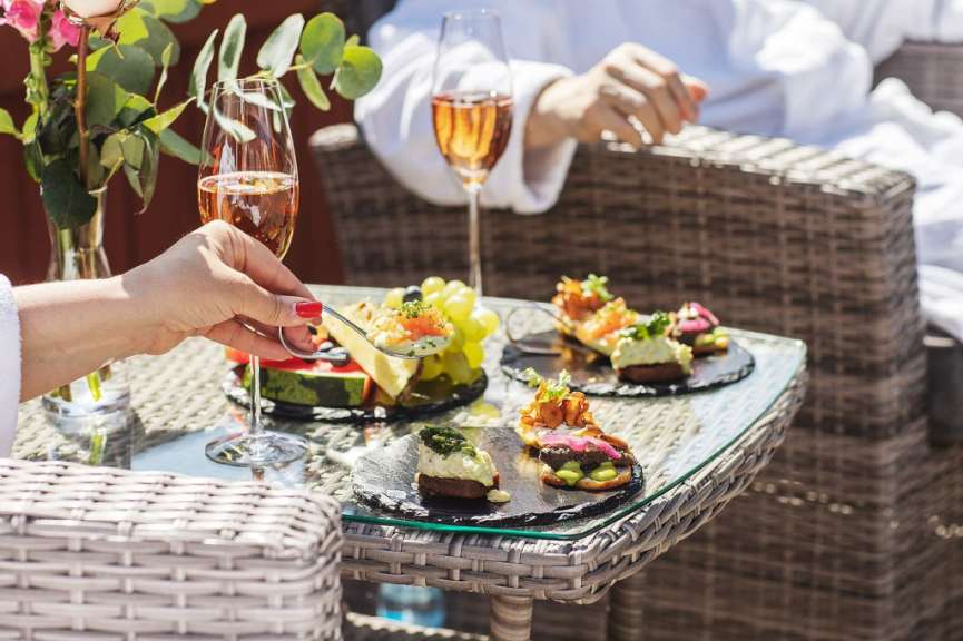 Eine Frau hält einen Löffel in der Hand und hält ein Glas Champagner
